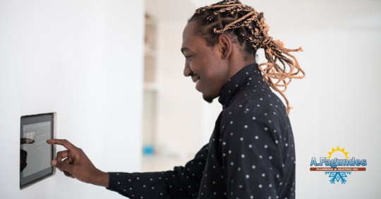 Man touching thermostat.